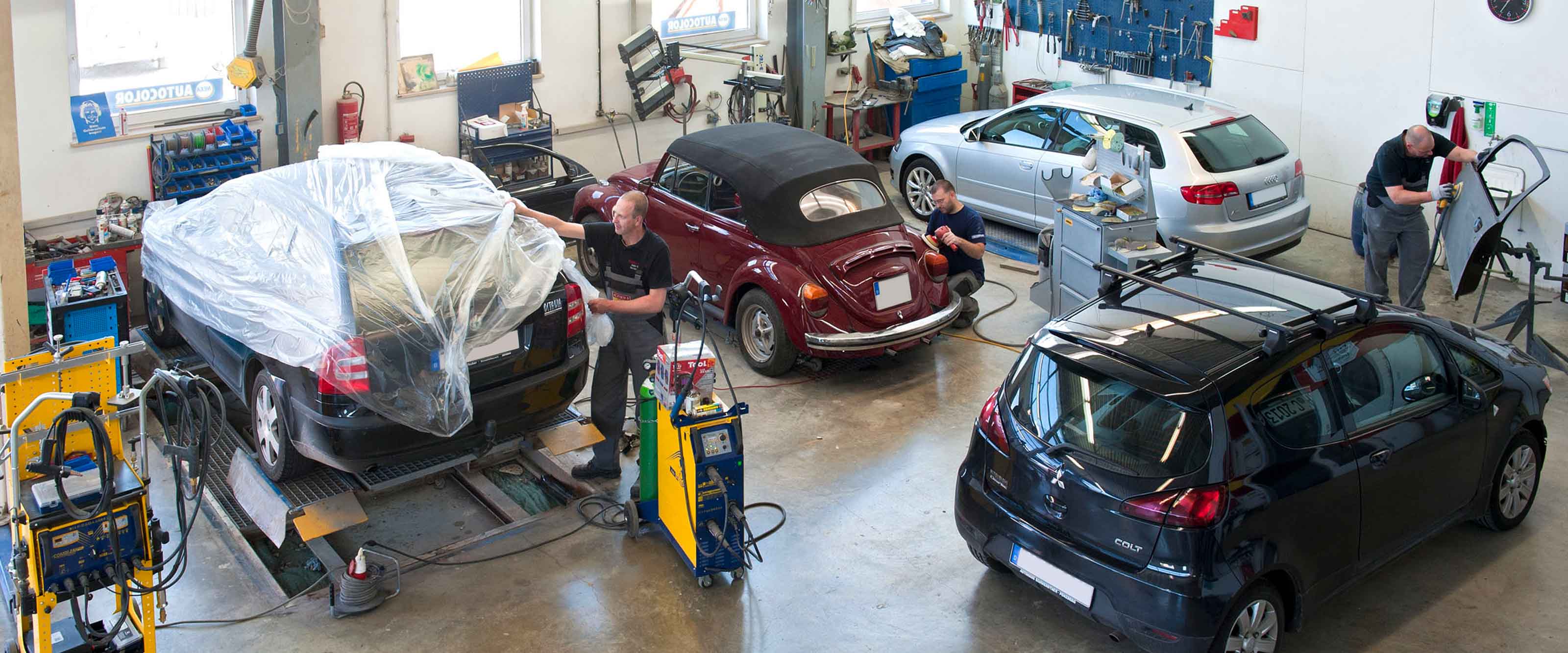 Werkstatt mit Fahrzeugen zur Lackierung.